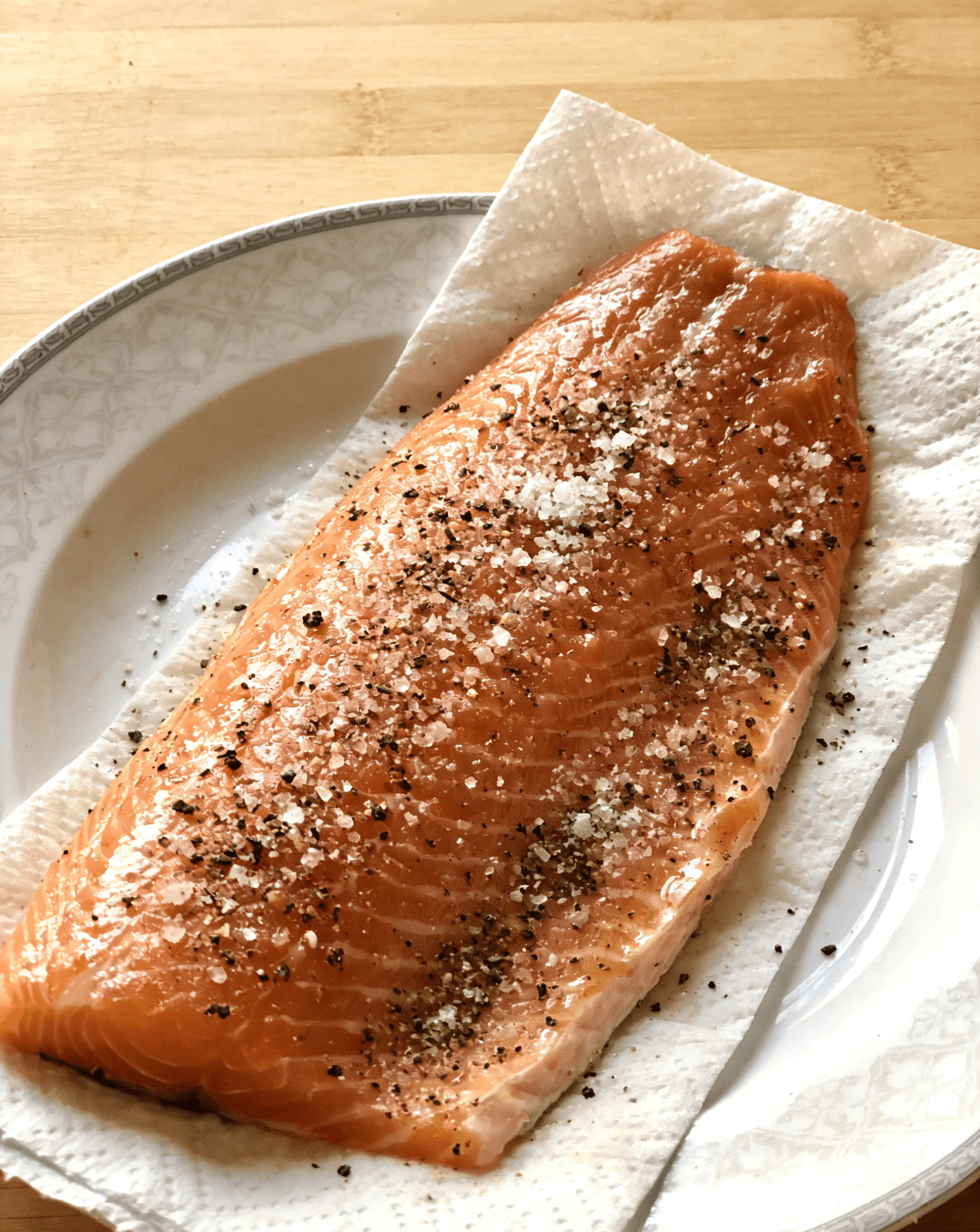 Seasoning salmon fillets with salt and pepper