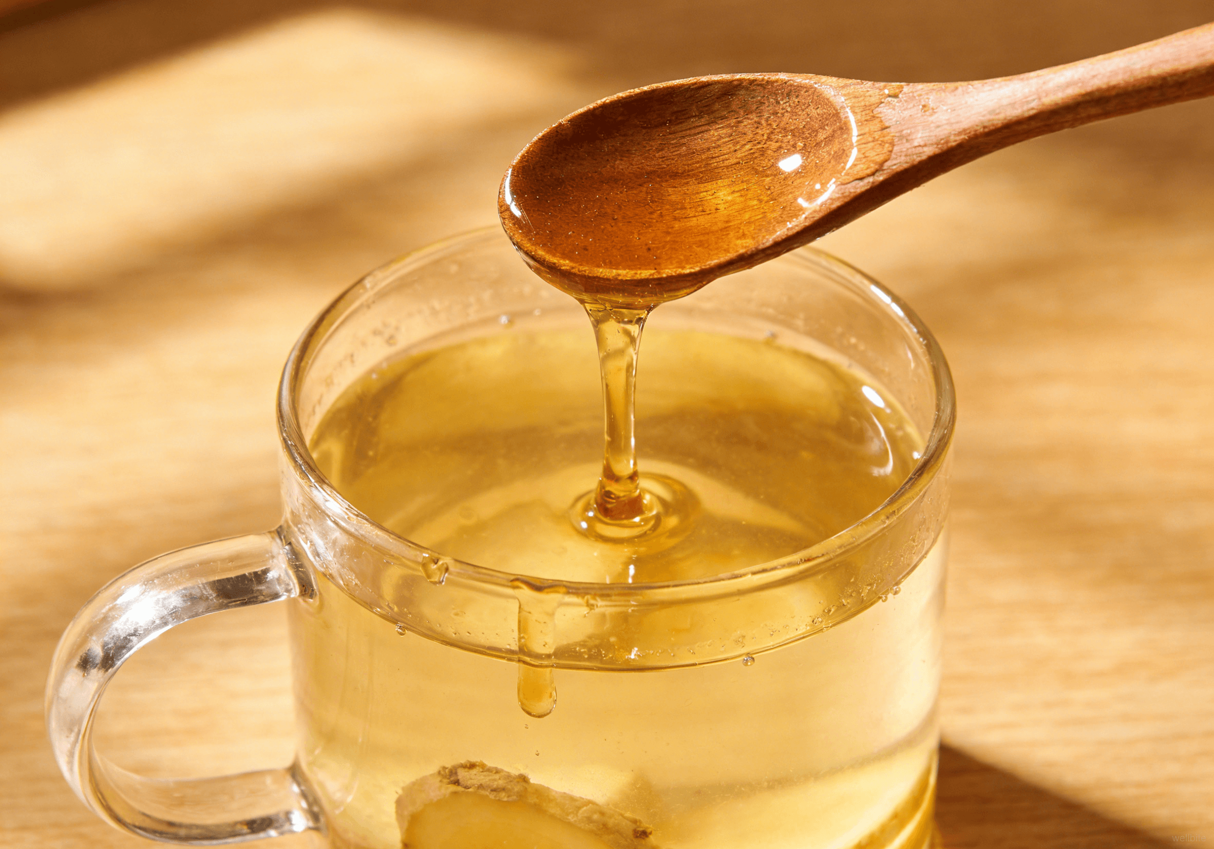 Raw honey being stirred into the beverage